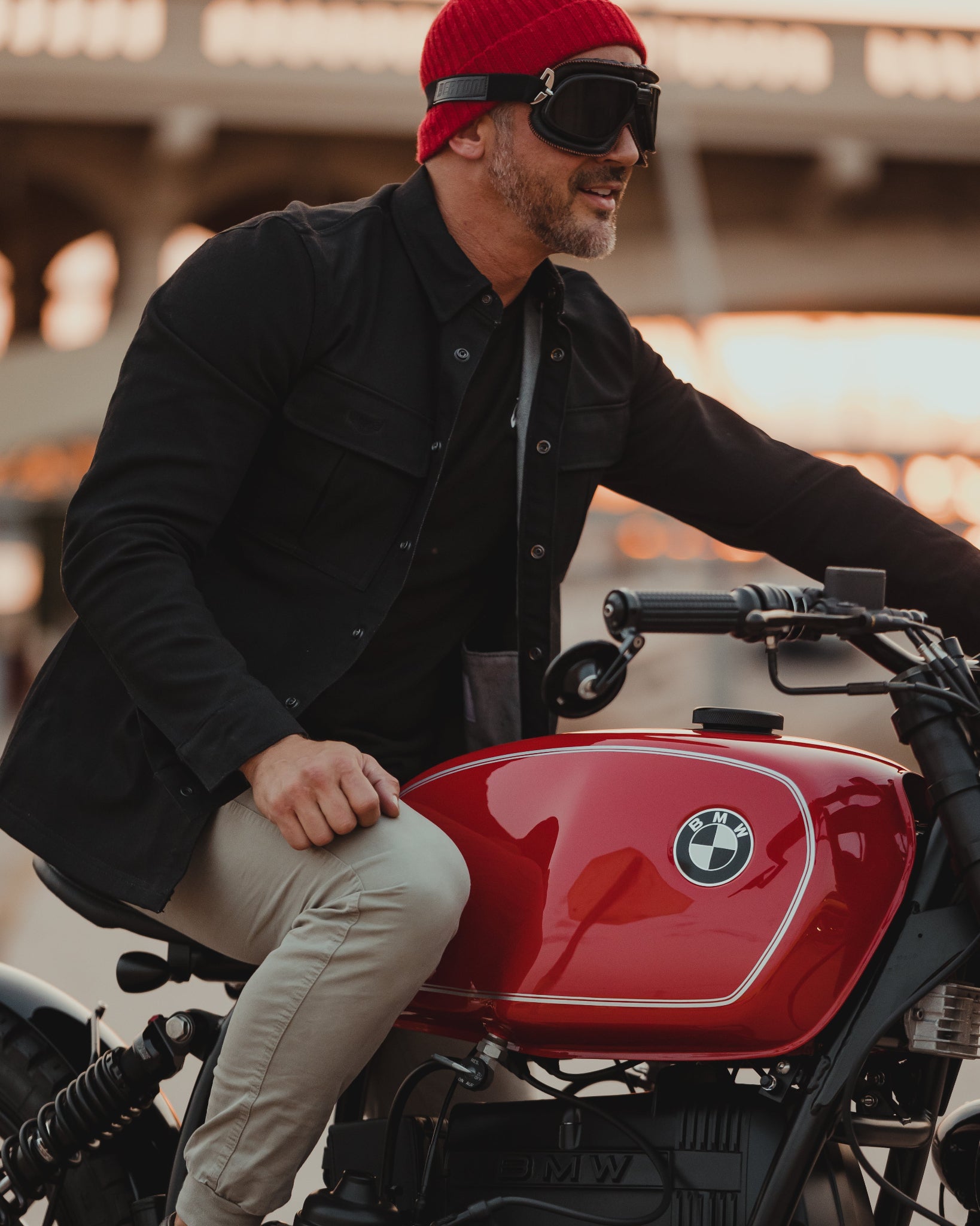 Male wearing denim motorcycle jacket on red BMW motorcycle